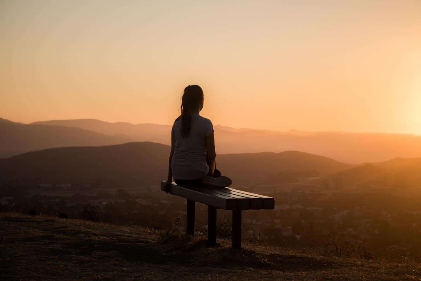 a woman relaxed meditating in with the sunrise